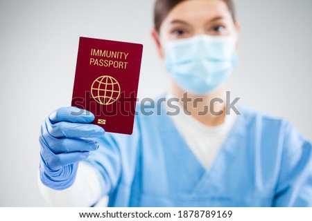 US doctor holding red global immunity passport,SARS re-infection risk-free PCR certificate concept,recovered COVID-19 patient receive convalescence proof,Coronavirus pandemic track trace ID document Royalty-Free Stock Photo #1878789169
