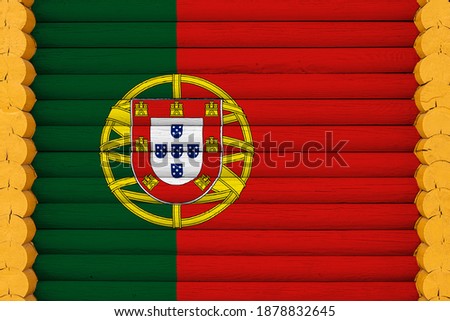 National flag  of Portugal on a wooden wall background. The concept of national pride and a symbol of the country. Flags painted on a house