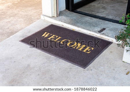 Welcome mat in shop front of door.
