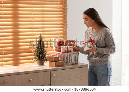 Woman with Christmas gifts at home. Advent calendar in basket