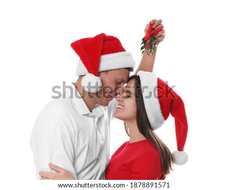 Happy couple under mistletoe bunch on white background