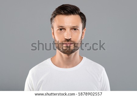 Portrait of handsome bearded man over grey studio background, empty space. Middle-aged bearded man posing for male magazine or blog, youth, healthy lifestyle and male cosmetology concept Royalty-Free Stock Photo #1878902557