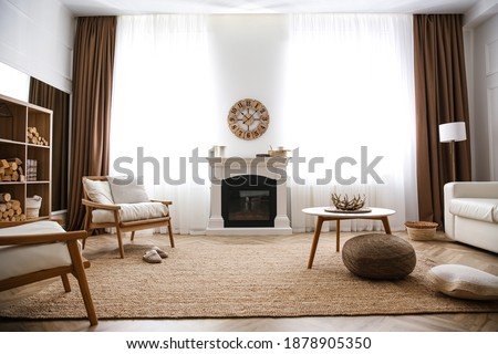 Elegant artificial fireplace and armchairs in room. Interior design