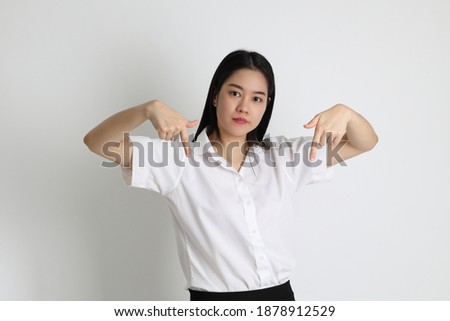 The Asian girl in university uniform standing on the white background.