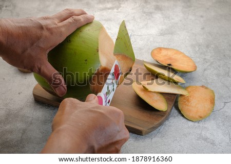 Man cutting a fresh coconut