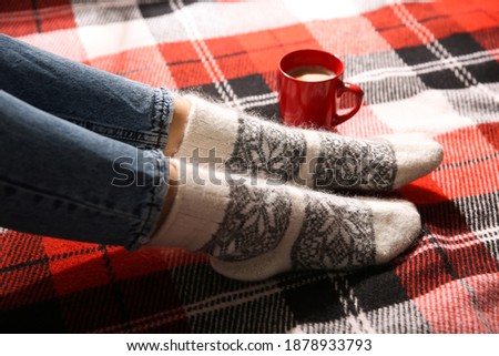 Woman relaxing on checkered plaid, closeup. Cozy season