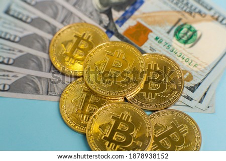 Golden Bitcoins on a background of dollars. New virtual money. Cryptocurrency. Finance and business.   
