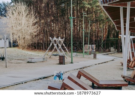 playground by the forest. Children's playground in winter. Winter games for children. Winter park near the forest with swings.
