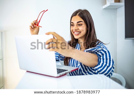 Female Assistant. Receptionist using laptop computer in modern office and writing notes, copyspace. Young smiling female receptionist at the modern office desk with a laptop ready to greet clients