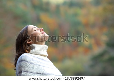 Side view portrait of a satisfied woman breathing fresh air in the mountain in winter Royalty-Free Stock Photo #1878992497