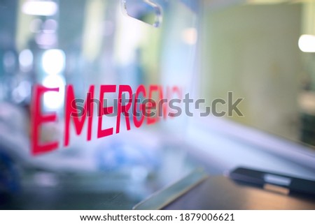 Transparent plastic divider on the reception desk in the hospital admission department with red lettering emergency. Royalty-Free Stock Photo #1879006621