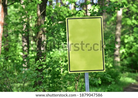 Yellow warning sign at the entrance to the forest. Empty space for text on signboard
