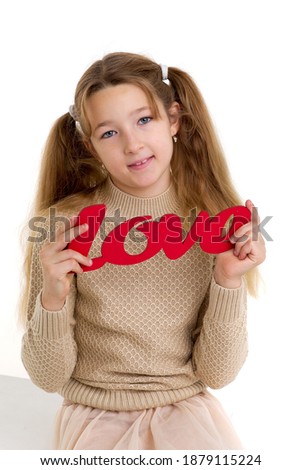 Preteen girl holding red word Love