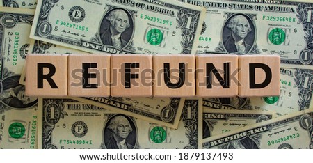 Refund symbol. Concept word 'refund' on wooden cubes on a beautiful background from dollar bills. Business and refund concept. Royalty-Free Stock Photo #1879137493