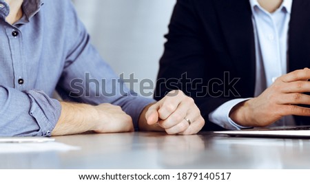 Business people using laptop computer while working together at the desk in modern office. Unknown businessman or male entrepreneur with colleague at workplace. Teamwork and partnership concept