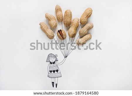 Cartoon of a girl holding real peanuts in her hand like balloons