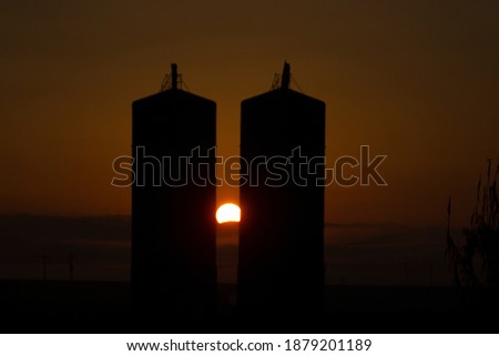 The Sun rising between the silos