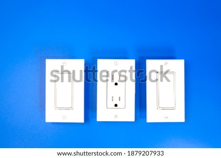 Two switches and a socket complete with covers, photo against a blue background