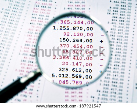 Magnifying glass focused an invoice with negative numbers. Royalty-Free Stock Photo #187921547