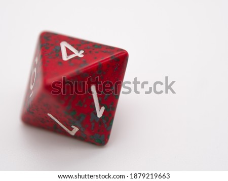 Red and green eight-sided die displaying a 4