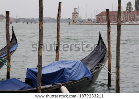 gondola on the water in Venice, gondola covered with foil and attached to wooden posts