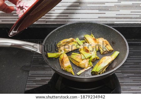 Artichokes and asparagus grilling in a pan