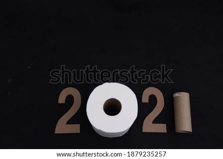 new year 2021 with a roll of toilet paper for the number 0 and remaining cardboard for the number 1, on black background, with space for writing
