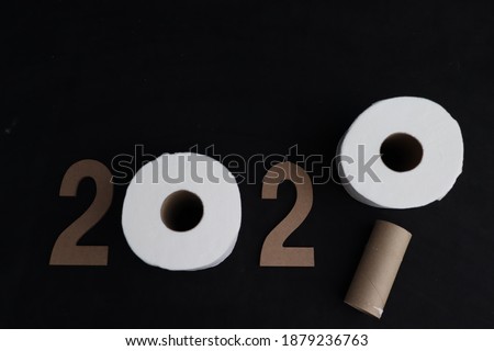 new year 2021 with a roll of toilet paper for the number 0 and remaining cardboard for the number 1, on black background, with space for writing