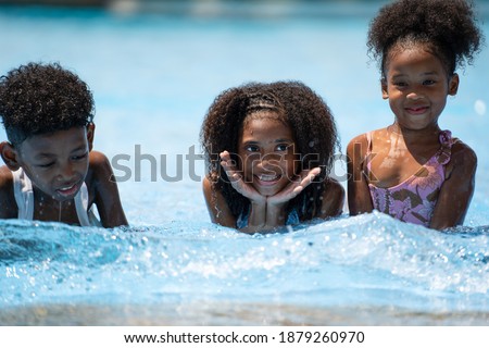 african girls lay down in swimming pool. Concept children self playing in summer day at outdoor activity sport recreation.