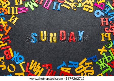 Sunday word of bright color letters on black background.