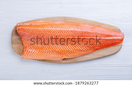 Half raw salmon fillet on wooden table, top view Royalty-Free Stock Photo #1879263277