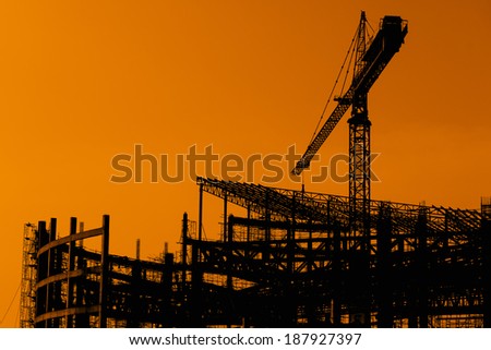 Derrick cranes in construction site on Silhouette background Stock Photo