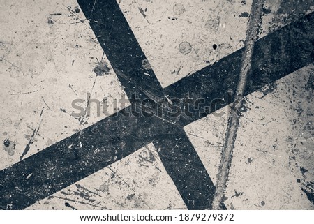 Grungy dark stylised black cross on a flat damaged surface.