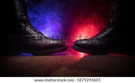 War concept. Old military shoe in a dark toned foggy background. Creative concept of conflict between countries, military aggression. Selective focus