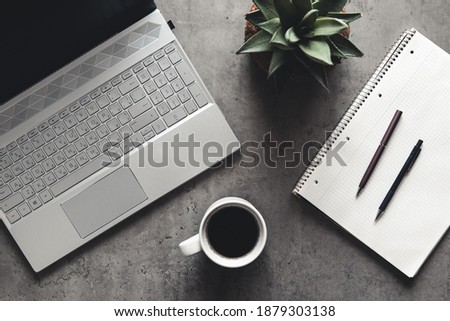 laptop and book, coffee on gray background, Top view of office desk on textured gray background