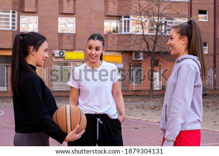 Three young basketball players interact on an urban court before the basketball game
