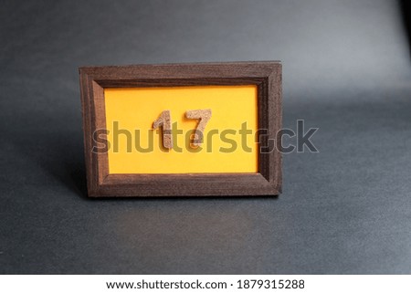 Number 17 in frame on orange background. Concept for art, education, celebration, and countdown.
