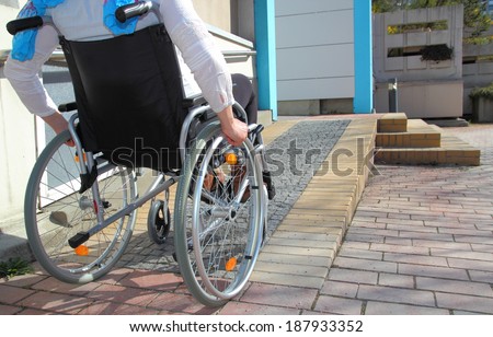 Woman in a wheelchair using a ramp Royalty-Free Stock Photo #187933352