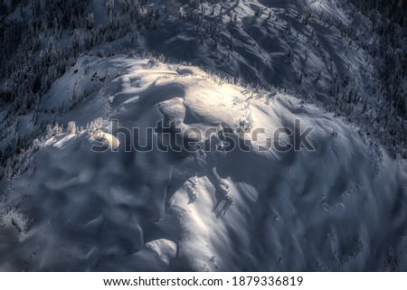 Aerial landscape view of the snow covered mountain range North of Vancouver, British Columbia, Canada. Artistic Dark Render