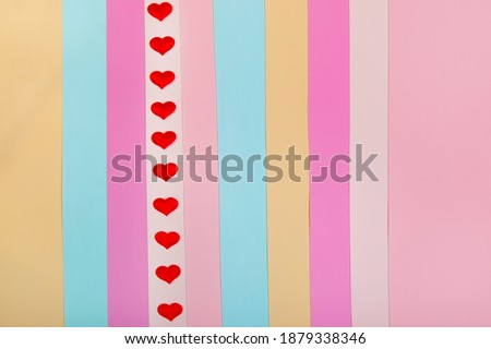 Red hearts on a multicolored striped background. For web design, postcard, banner. Valentine's Day, Wedding, Birthday, International Women's Day. Copy space.