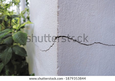 Cracked concrete building broken wall at the outside cement corner that effected with earthquake and collapsed ground Royalty-Free Stock Photo #1879353844