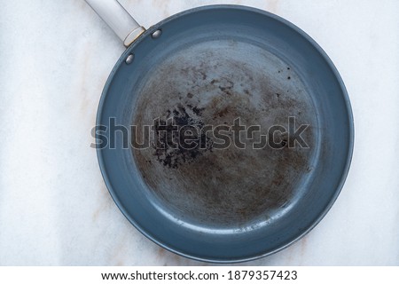 A ruined, non stick skillet on the kitchen counter Royalty-Free Stock Photo #1879357423