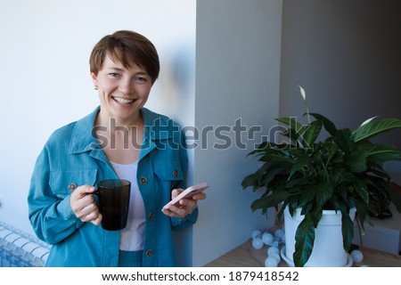 the concept of employment, interviews, advertising digital technology - woman drinking coffee and talking on the phone. Smiling woman with cup makes a call. Morning of girl