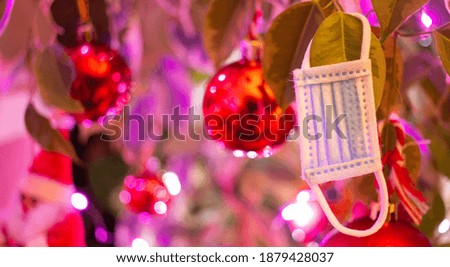 Surgical mask hanging from the Christmas tree. Safe Christmas. Banner. Background. Decoration.