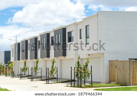 A row of residential townhomes or townhouses in Melbourne's suburb, VIC Australia. Concept of real estate development, the housing market, and homeownership. Royalty-Free Stock Photo #1879466344