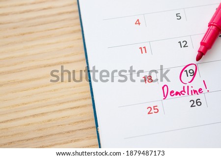 Deadline write on white calendar page date close up