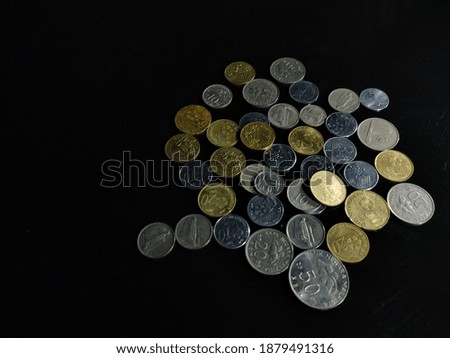 Selective focus.Coins scattered on a black background.Shot were noise and film grain in full resolution.