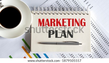 Notepad with the text Marketing Plan on light background, with coffee