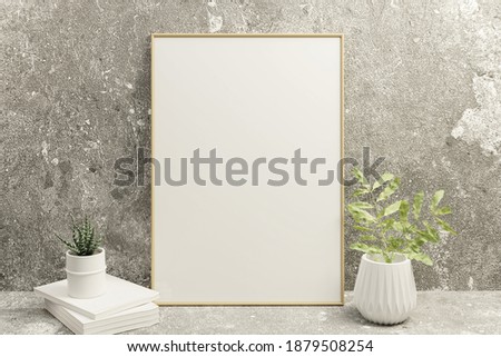A picture frame on the floor with a flower vase.