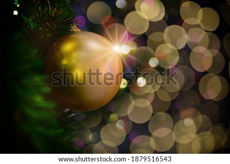 Golden color decoration christmas ball on christmas tree on abstract bokeh blurred background. Happiness festive party concept and 